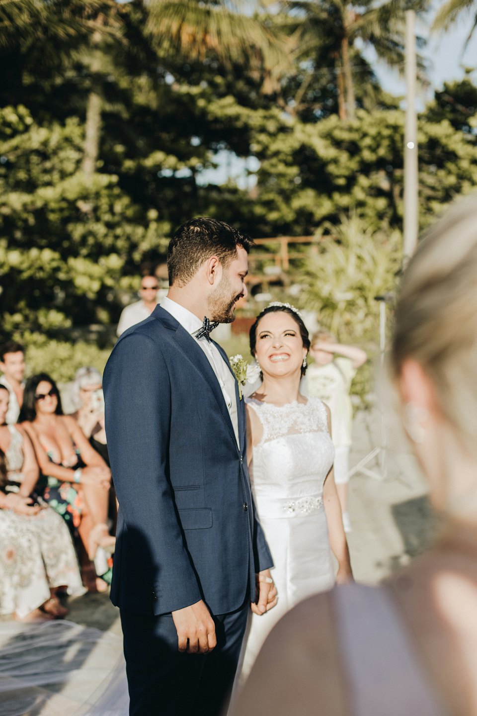 Bride and groom smiling at each other during an outdoor wedding.