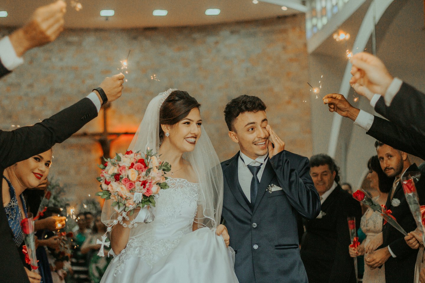 Bridal couple celebrating with sparklers after their wedding ceremony.